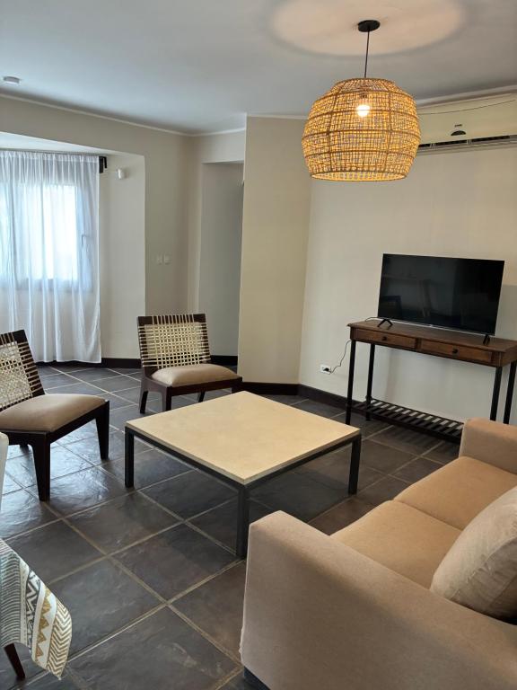 un salon avec un canapé, une table et une télévision dans l'établissement White House Cafayate, à Cafayate