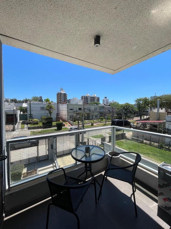 a balcony with a table and chairs and a large window at Hermoso apartamento en Buceo! in Montevideo