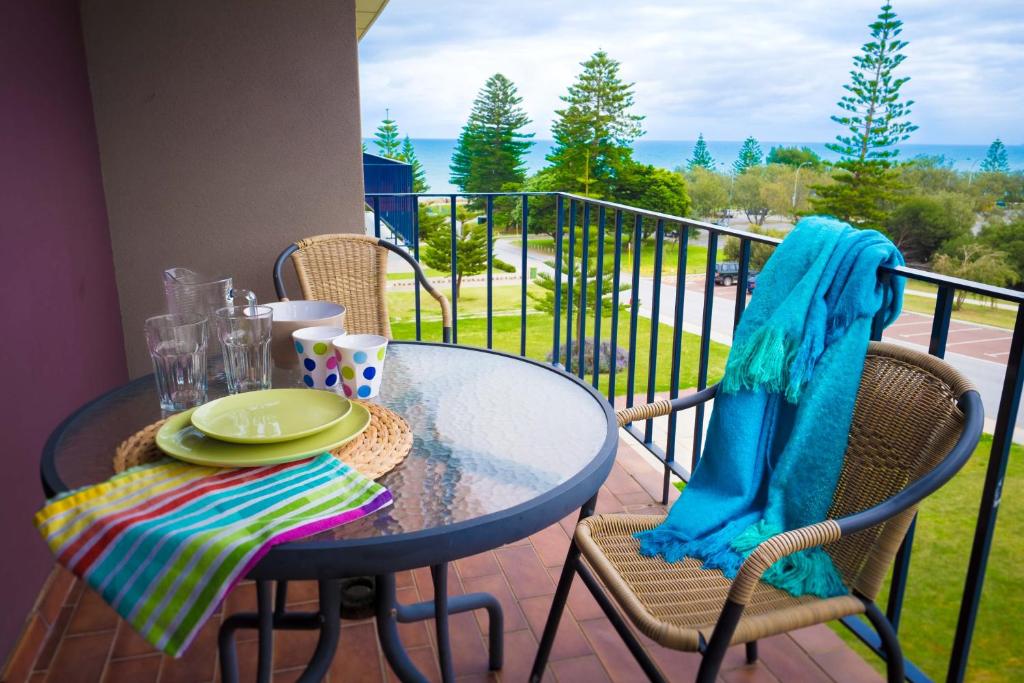 a table and chairs on a balcony with a view at Cottesloe Sea Bliss Apartment in Perth