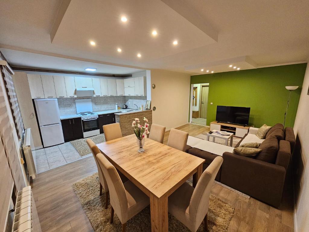 ein Wohnzimmer und eine Küche mit einem Tisch und einer Couch in der Unterkunft Casa bianca Pale in Pale