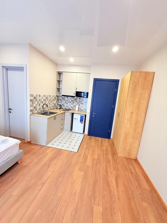 an empty kitchen with a blue door in a room at Cosy City-View Flat in Mtatsminda, flat 6 in Itʼkhvisi