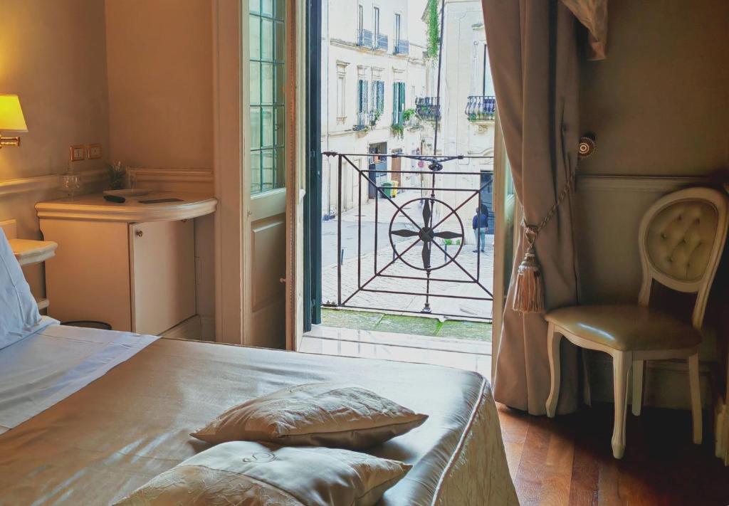een slaapkamer met een bed, een raam en een stoel bij Suite Hotel Santa Chiara in Lecce