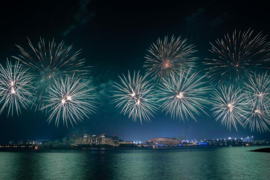 a group of fireworks in the sky over the water at Stylish Cozy Studio Yas Island NYE Fireworks 5 Min Away in Abu Dhabi