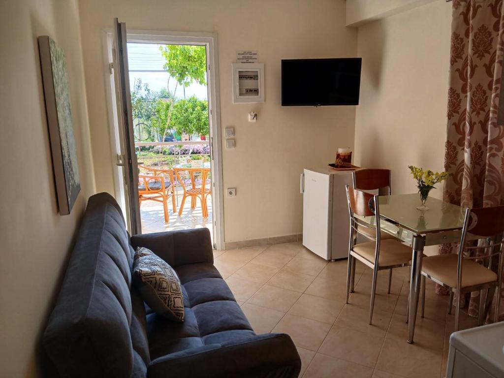 un salon avec un canapé bleu et une table dans l'établissement vasiliki's Apartments, à Dhímitra