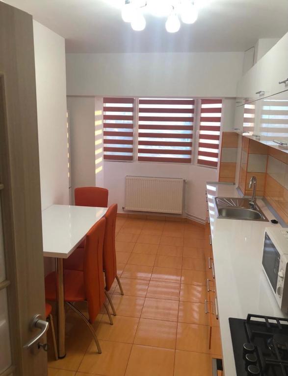a kitchen with a table and chairs and a sink at Apartament central in Ploieşti