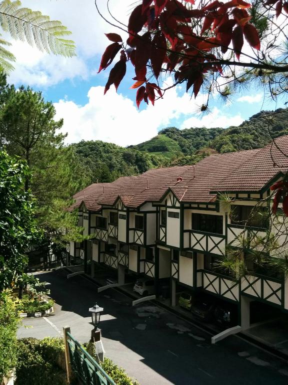 a building with a mountain in the background at Mary Apt @ Equatorial Hill Resort in Cameron Highlands