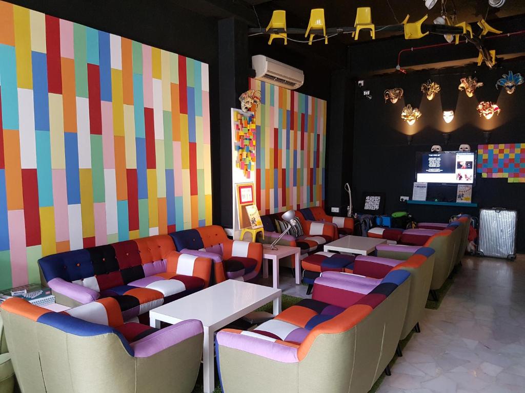 ein Restaurant mit farbenfrohen Wänden, Tischen und Stühlen in der Unterkunft The Bohemian in Singapur