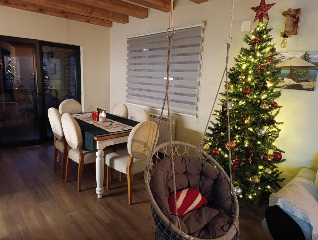 a christmas tree in a living room with a table and chairs at Villa Dussi in Žabljak