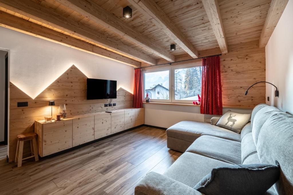 a living room with a couch and a tv at - Punta Penia - Canazei center app in Canazei