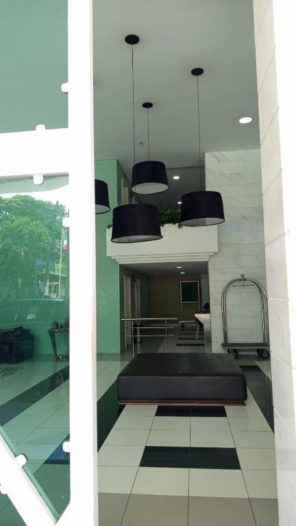 a room with a bed and chairs in a building at Bussines Flat Iguatemi in Salvador