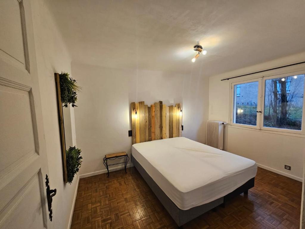 een slaapkamer met een groot wit bed en een raam bij Les 3 vallées 1 in Séranon