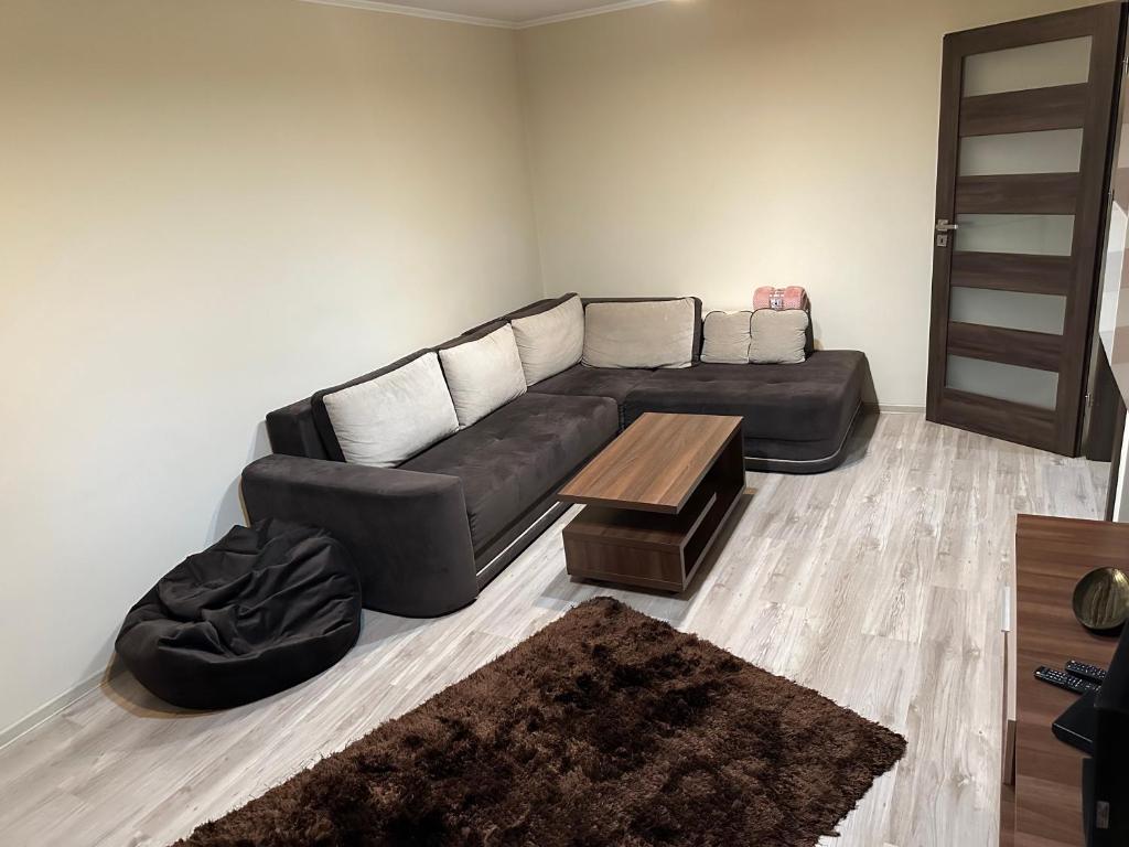 a living room with a black couch and a coffee table at Republicii Central in Ploieşti