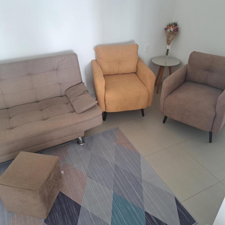 a living room with two chairs and a couch at Apto 3 quartos Centro Torres RS in Torres