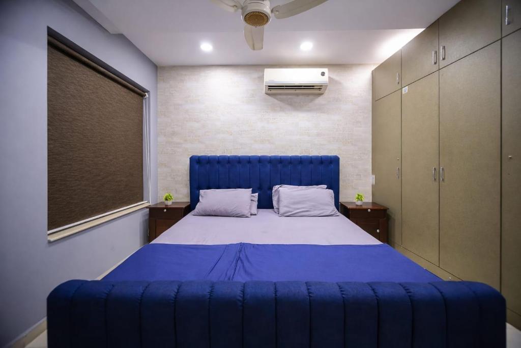 a large blue bed in a room with a window at Private 2BD Apartment Opposite Dha Phase 8 in Lahore