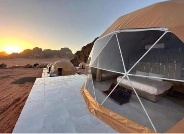 een tent midden in een woestijn met zonsondergang bij RUM MOON lUXURY CAMP in Wadi Rum