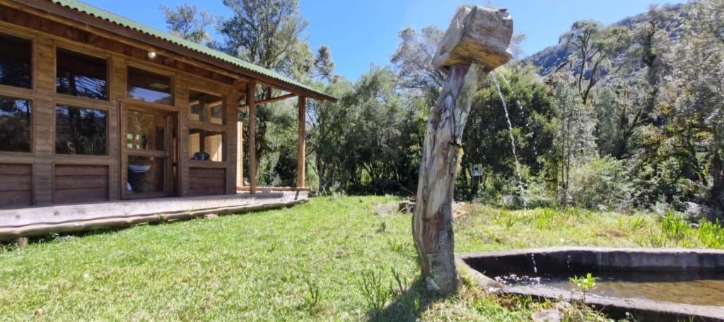 a wooden house in the middle of a field at Refúgio Bocaina in Bocaina do Sul