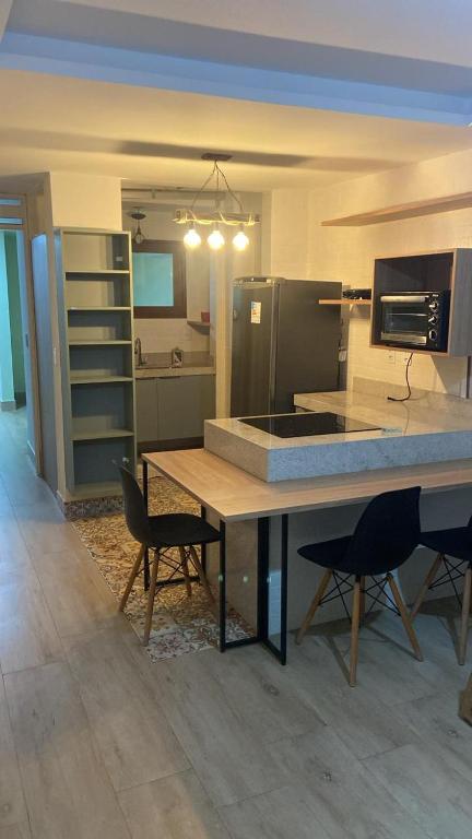 a kitchen with a table and chairs in a room at Apartamento charme in Praia do Frances