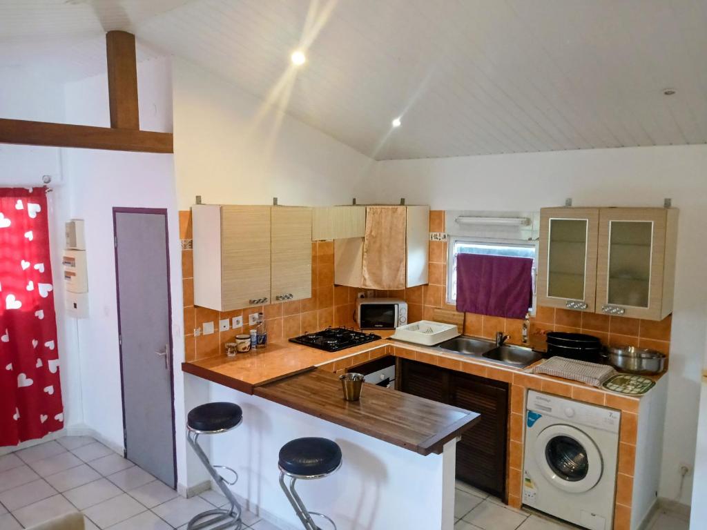 a kitchen with a sink and a stove top oven at Le Milano in Kourou
