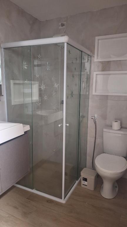 a bathroom with a glass shower and a toilet at Apartamento charme in Marechal Deodoro