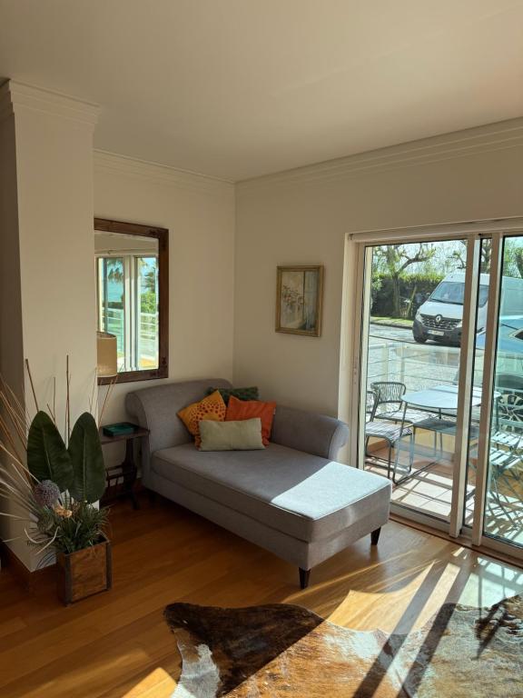 een woonkamer met een bank en een glazen schuifdeur bij T1 Sea & Pool in Caxias