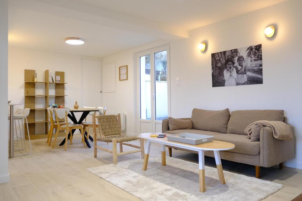 ein Wohnzimmer mit Sofa und Tisch in der Unterkunft Les vagues - Sea view house in Saint-Martin-Plage