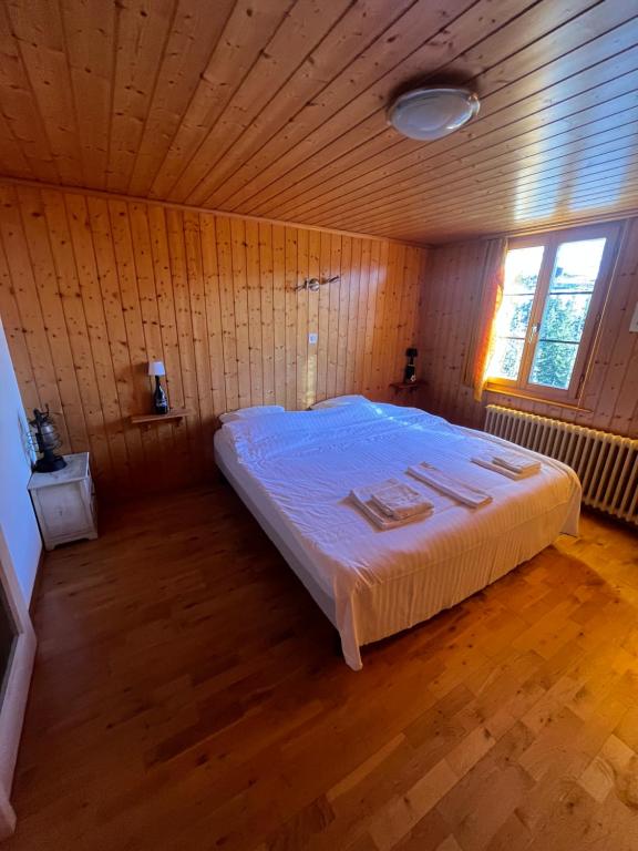 a large bed in a room with a wooden ceiling at L'Auberge de la Combal in La Comballaz