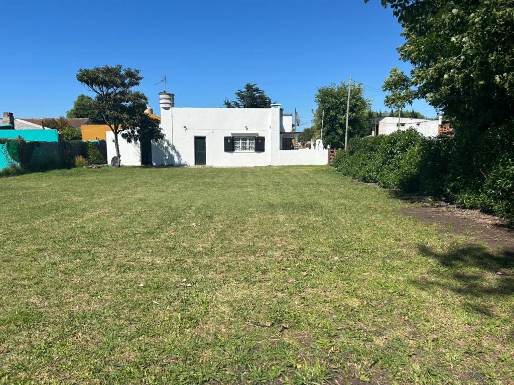 un ampio cortile con una casa bianca sullo sfondo di Alquiler miramar a Miramar