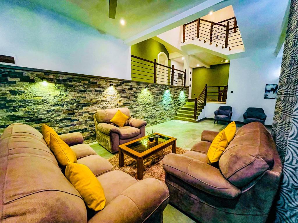 een woonkamer met 2 banken en een stenen muur bij Elevate Villa Galle in Galle
