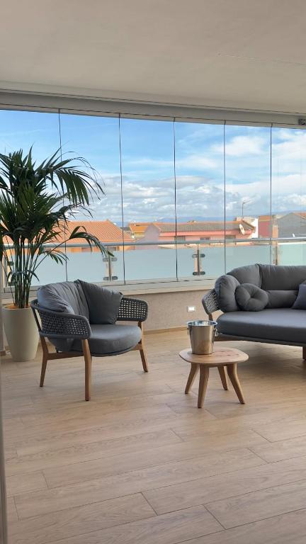 a living room with two couches and a large window at Mediterranea Apartments Aurora in Assemini
