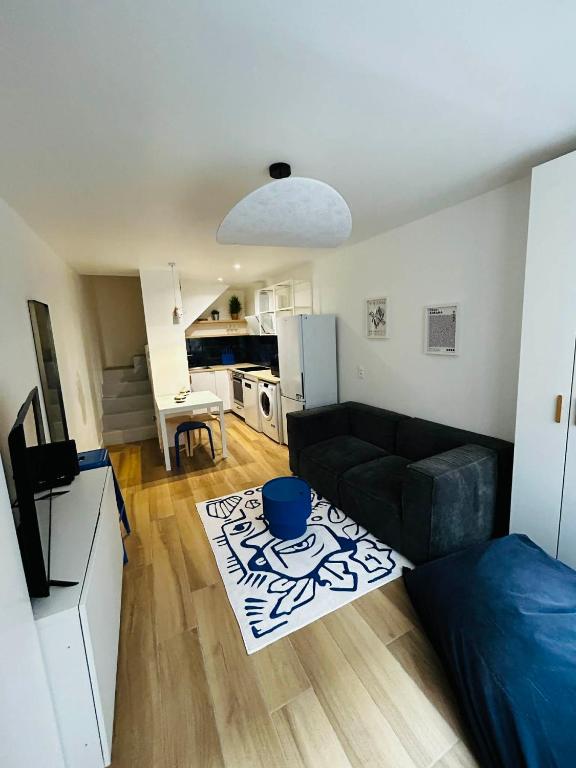 a living room with a couch and a kitchen at Maison et chambre privée - Bordeaux in Bordeaux