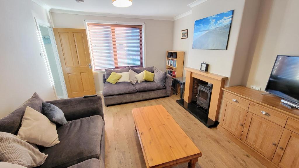 a living room with a couch and a television at Stornoway Stays in Stornoway