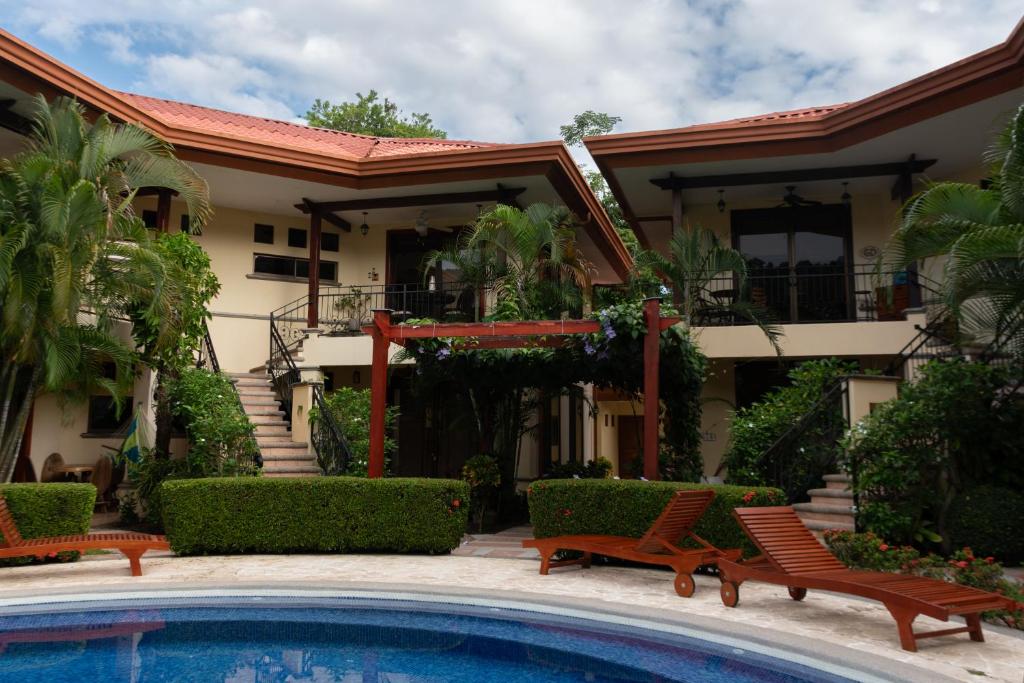 a house with a swimming pool in front of a house at Corteza 2BD Gated AC Quiet Terrace Pools in Jacó