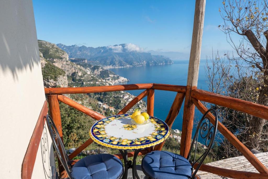 阿马尔菲JoRi Vista Amalfi的阳台上的桌子和椅子，可欣赏海景