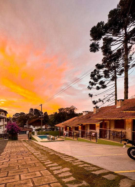 a sunset over a parking lot in front of buildings at Pousada Bosque in Monte Verde