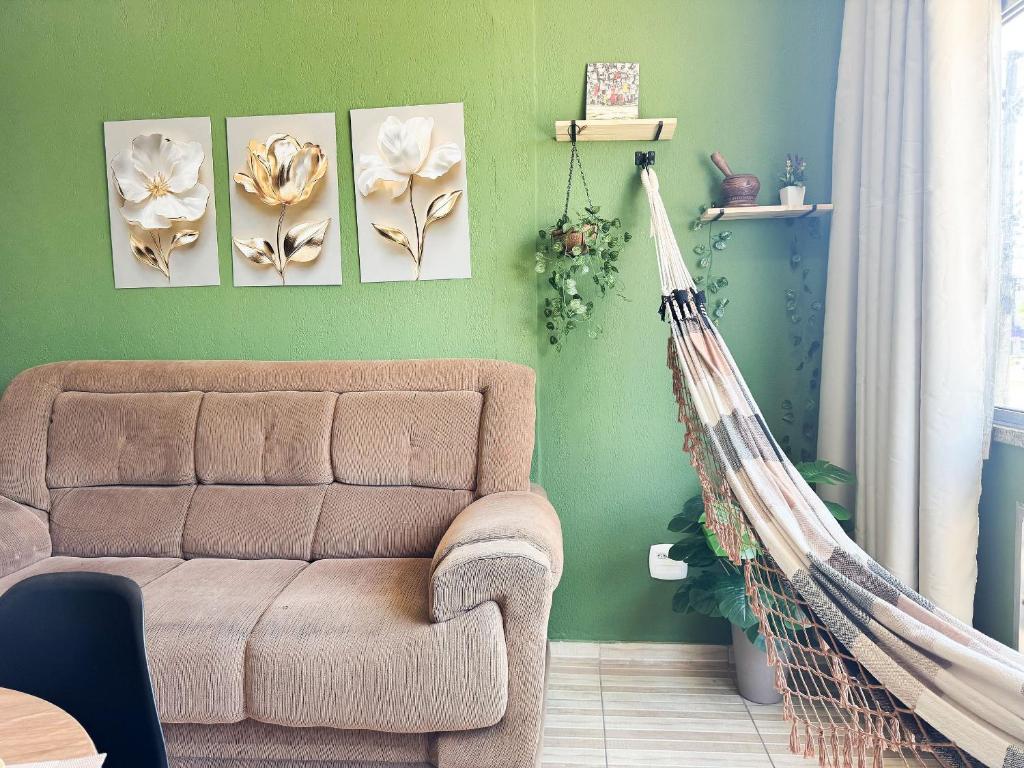 a living room with a couch and a hammock at Apto na beira da praia do Centro | ROMM109 in Rio das Ostras