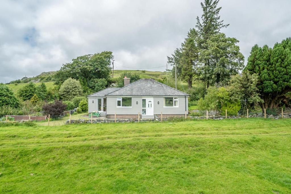 a white house in the middle of a field at Hendre-Llangwm in Llangwm