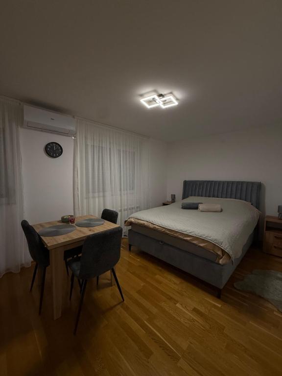 a bedroom with a bed and a table in it at Apartmani Sirius in Čačak