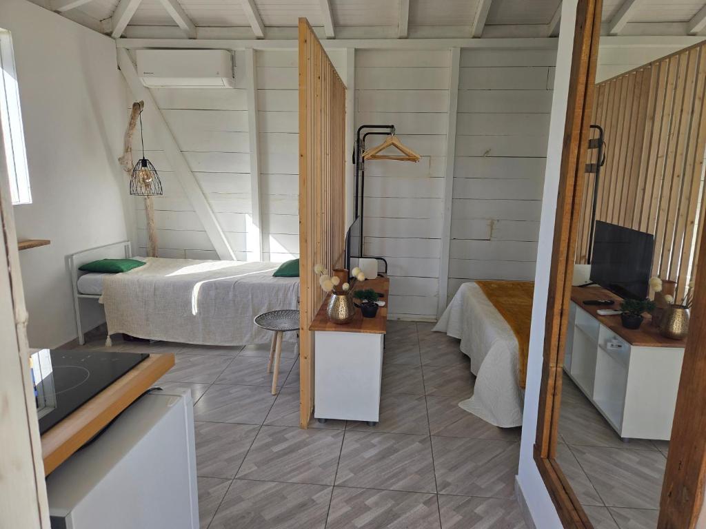 a bedroom with a bed and a sink in a room at Guayaba in Sainte-Anne
