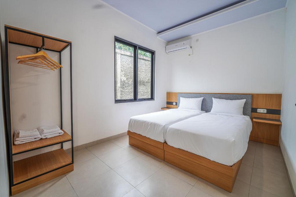 een slaapkamer met een groot wit bed en een raam bij Naava Village in Tagalbato