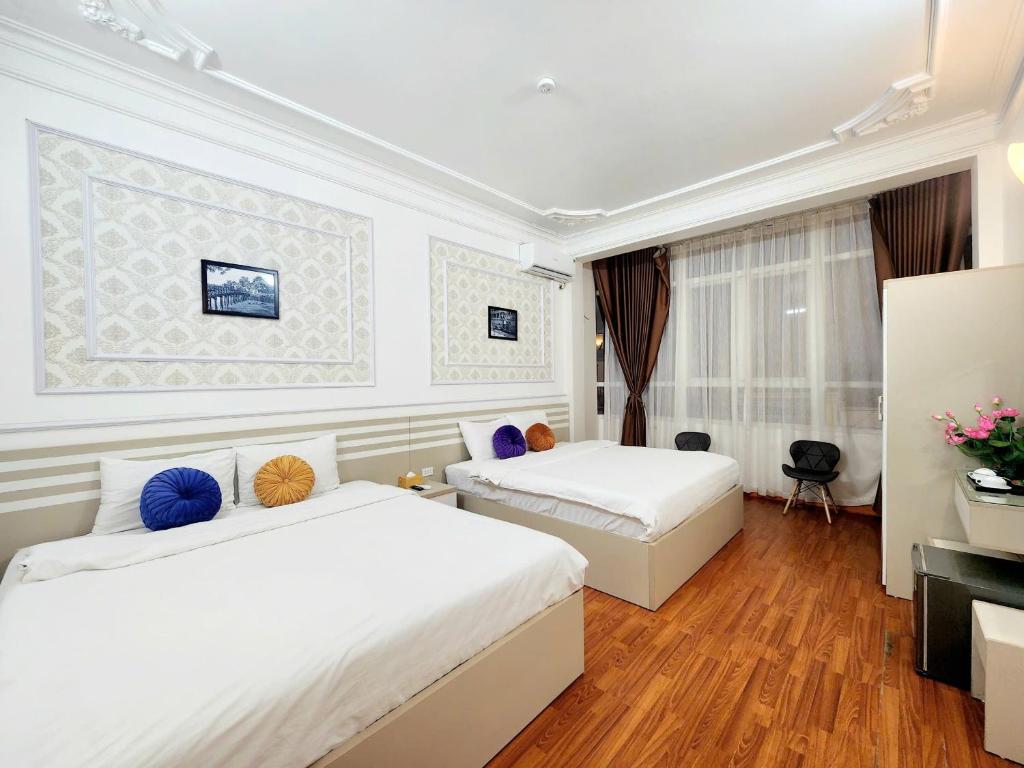 een hotelkamer met twee bedden en een televisie bij The Lake Silk Hanoi Boutique Hotel & Spa in Hanoi