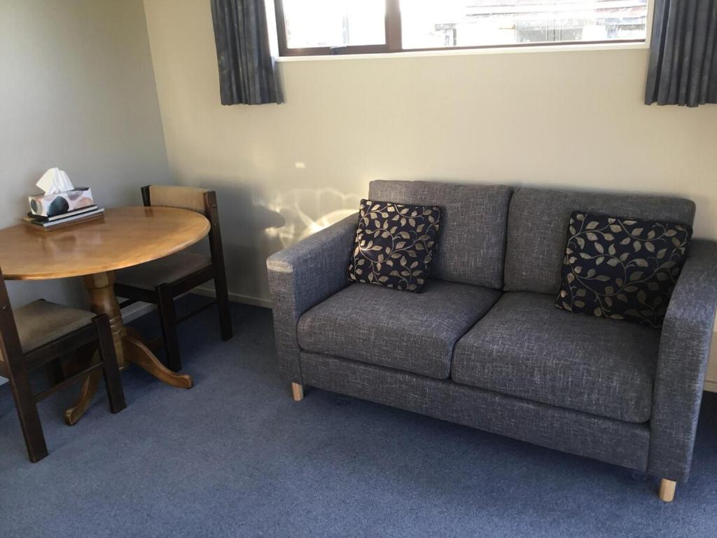 a living room with a couch and a table at South Catlins Cottage in Tokanui