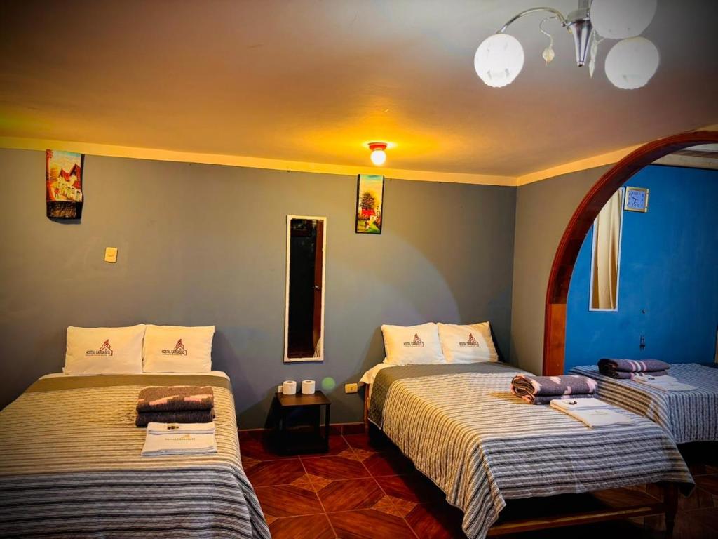 zwei Betten in einem Zimmer mit blauen Wänden in der Unterkunft Hospedaje Carrasco Cajamarca in Cajamarca
