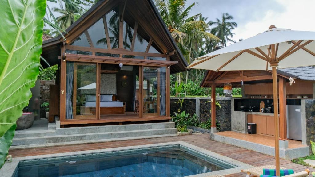 a villa with a swimming pool and a guest house at Sanis House in Penginyahan