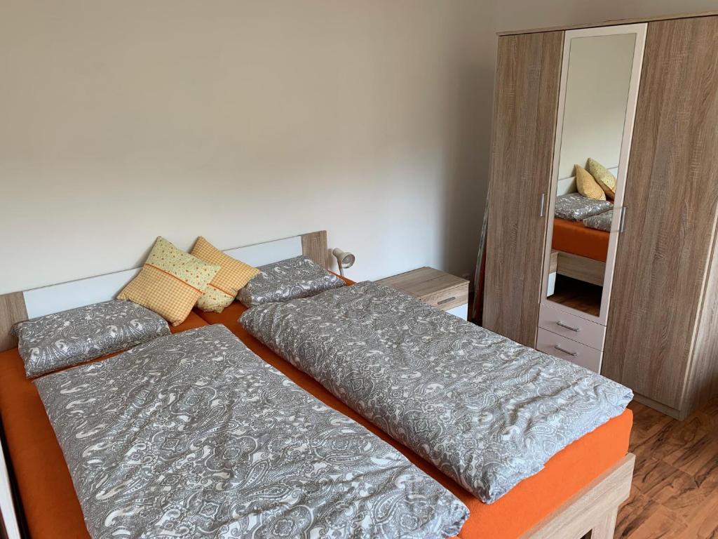 a bedroom with two beds and a mirror at Útulný apartmán v Jizerkách in Hejnice