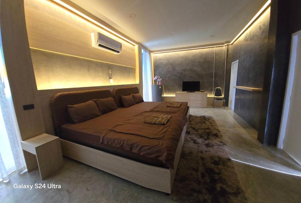 a bedroom with a large bed in a room at Maderlar Farm Restaurant & Resort in Ban Kao Lieo