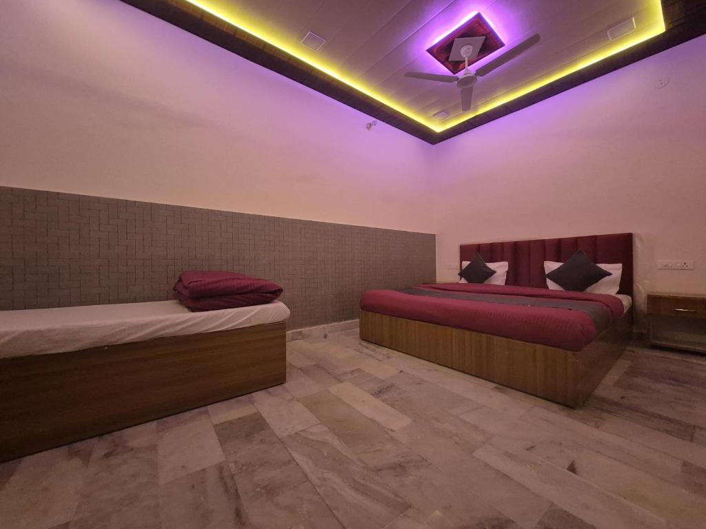 two beds in a room with a purple lighting at The Street Homestay-600m from Taj Mahal in Agra