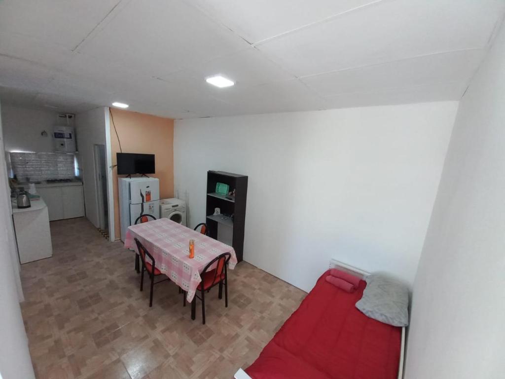 a living room with a table and a red couch at Departamento LA PALMERA ARGENTINA in San Luis