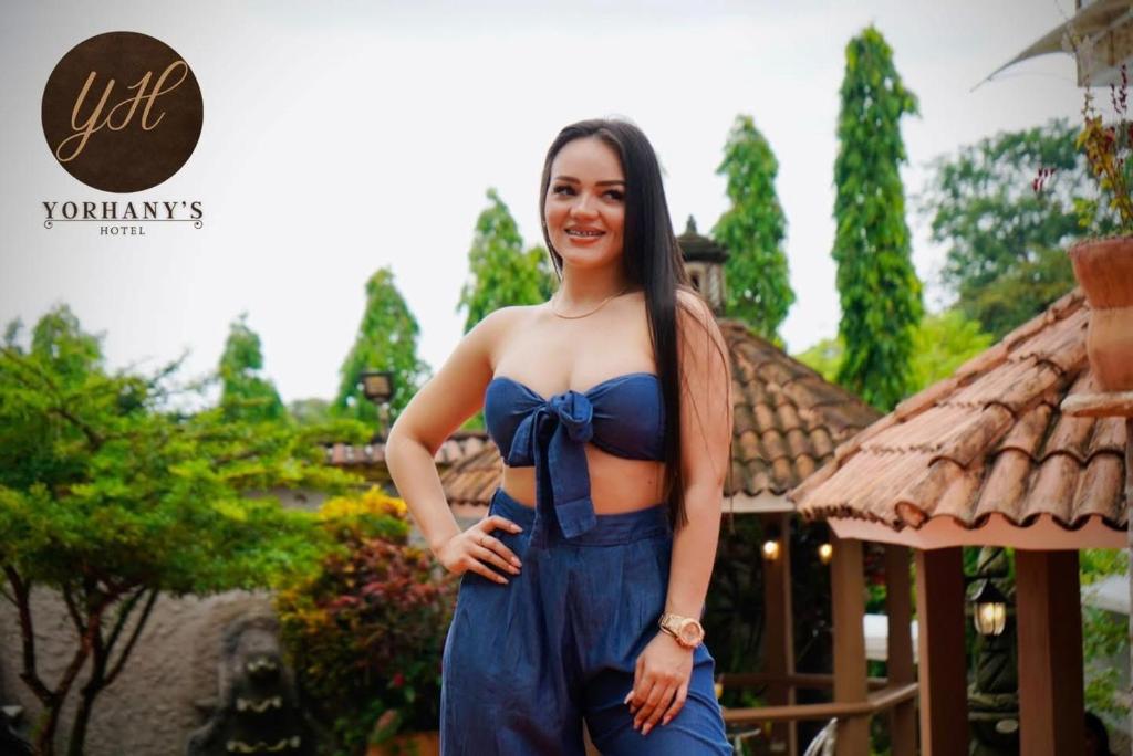 巴里奥斯港Yorhanys Hotel的一位身穿蓝色连衣裙、系着蝴蝶结的女士