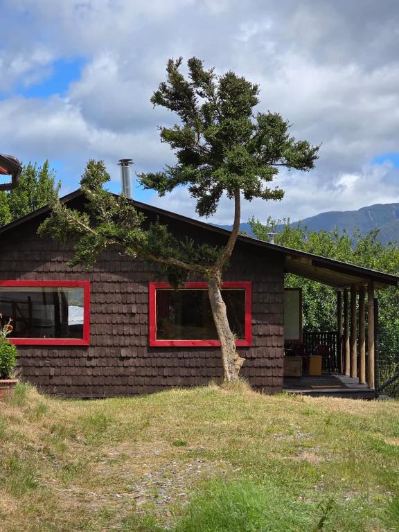a small house with a tree in front of it at Cabaña 1 - Rancho Doble AA in La Junta