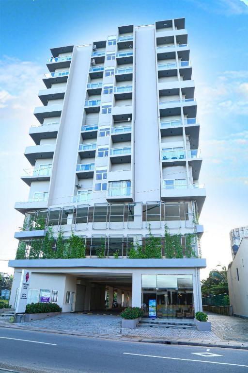 a large white building with plants on the side of it at Studio apartment ocean breeze in Negombo